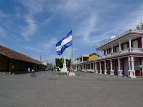 Granada, Nicaragua Plaza de la Independencia street view with Nicaraguan flag – Best Places In The World To Retire – International Living